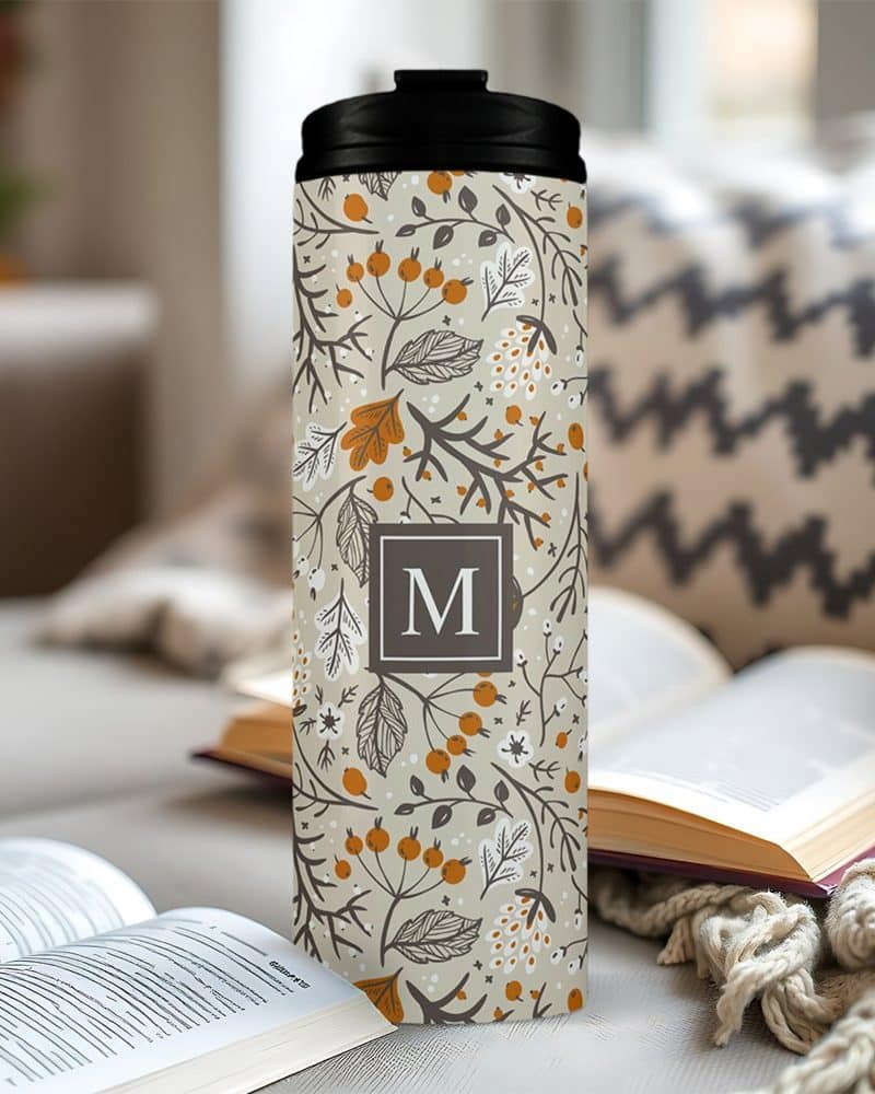 Beige travel tumbler with autumnal floral pattern and monogrammed M.