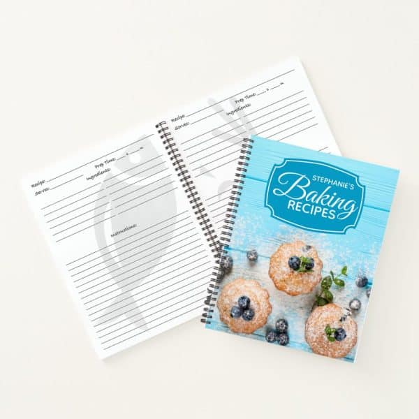 Spiral-Bound Baking Recipe Book With Blank Recipe Pages And A Cover Featuring Muffins And Blueberries.