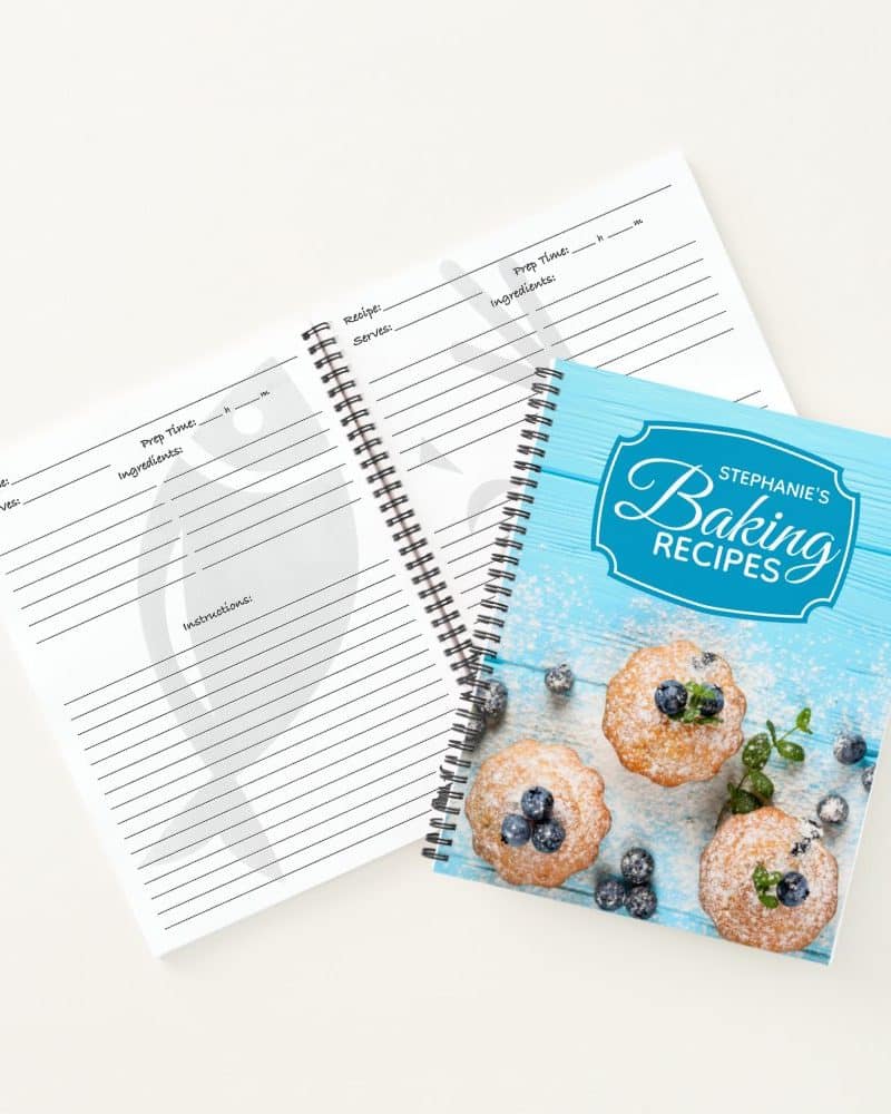 Spiral-bound baking recipe book with blank recipe pages and a cover featuring muffins and blueberries.