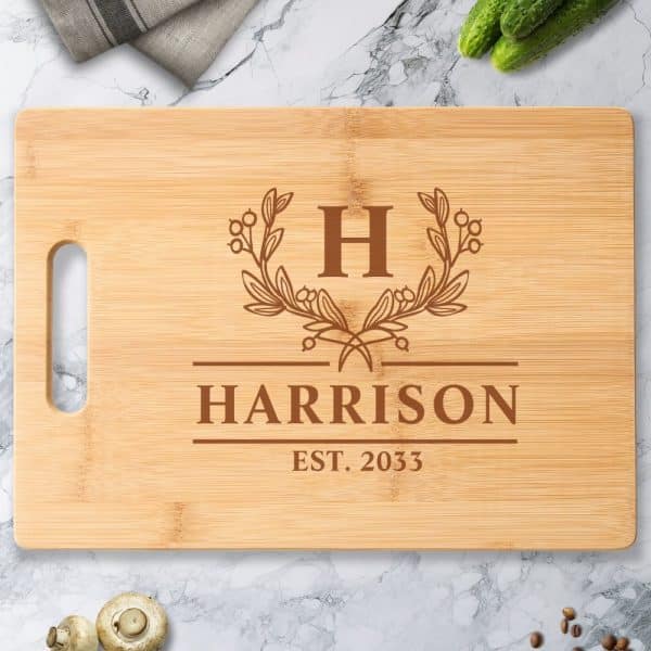 Light Brown Bamboo Cutting Board With A Monogrammed Design. The Design Includes The Initial H, The Last Name Harrison, And The Date 2033.