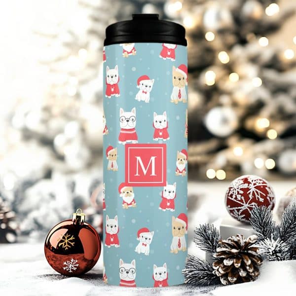 A Travel Mug With A Christmas Design Featuring French Bulldogs Wearing Santa Hats And Sweaters. The Mug Is Personalized With The Letter M.