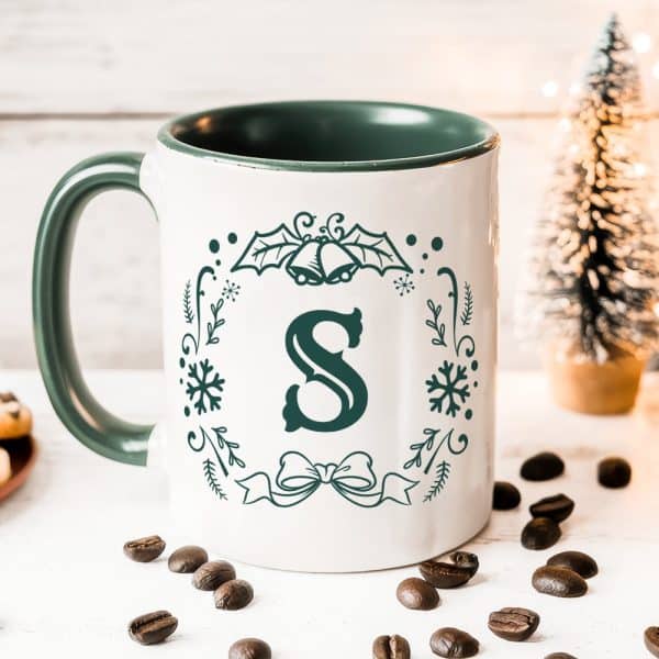 White Coffee Mug With Green Interior And A Dark Green Christmas Design Featuring The Letter S.