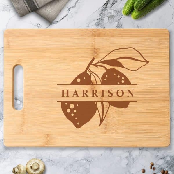 Personalized Bamboo Cutting Board With A Brown Engraved Design Of Lemons And The Name Harrison.
