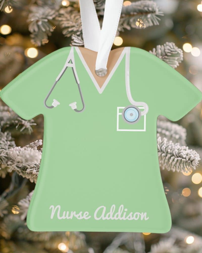 Light green nurse scrubs-shaped Christmas ornament with the name Nurse Addison.