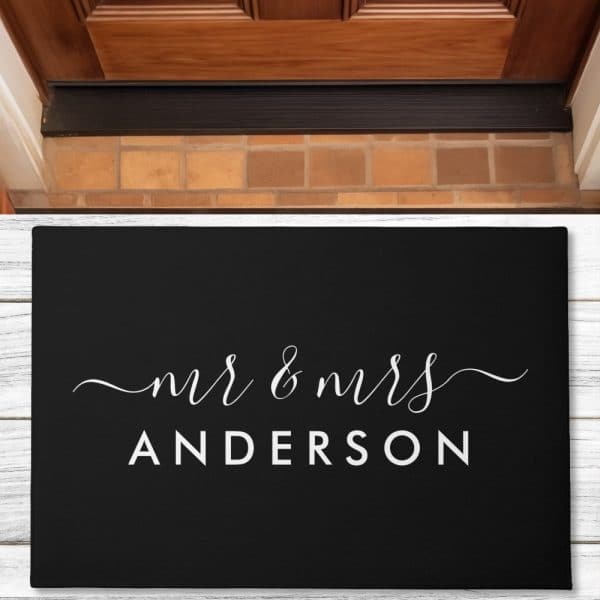 Black Welcome Mat With The Words Mr &Amp; Mrs Anderson In White Script Lettering.