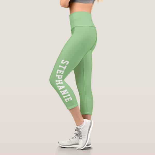 A Woman'S Light Green Capri Leggings With The Name Stephanie Printed Vertically On The Side.
