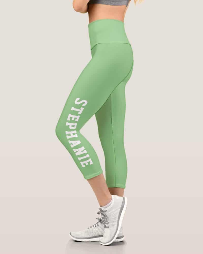 A woman's light green capri leggings with the name Stephanie printed vertically on the side.