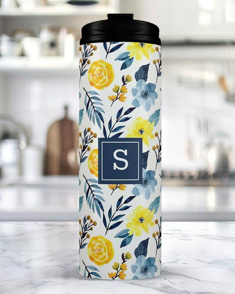 Floral travel tumbler with a navy blue initial S.