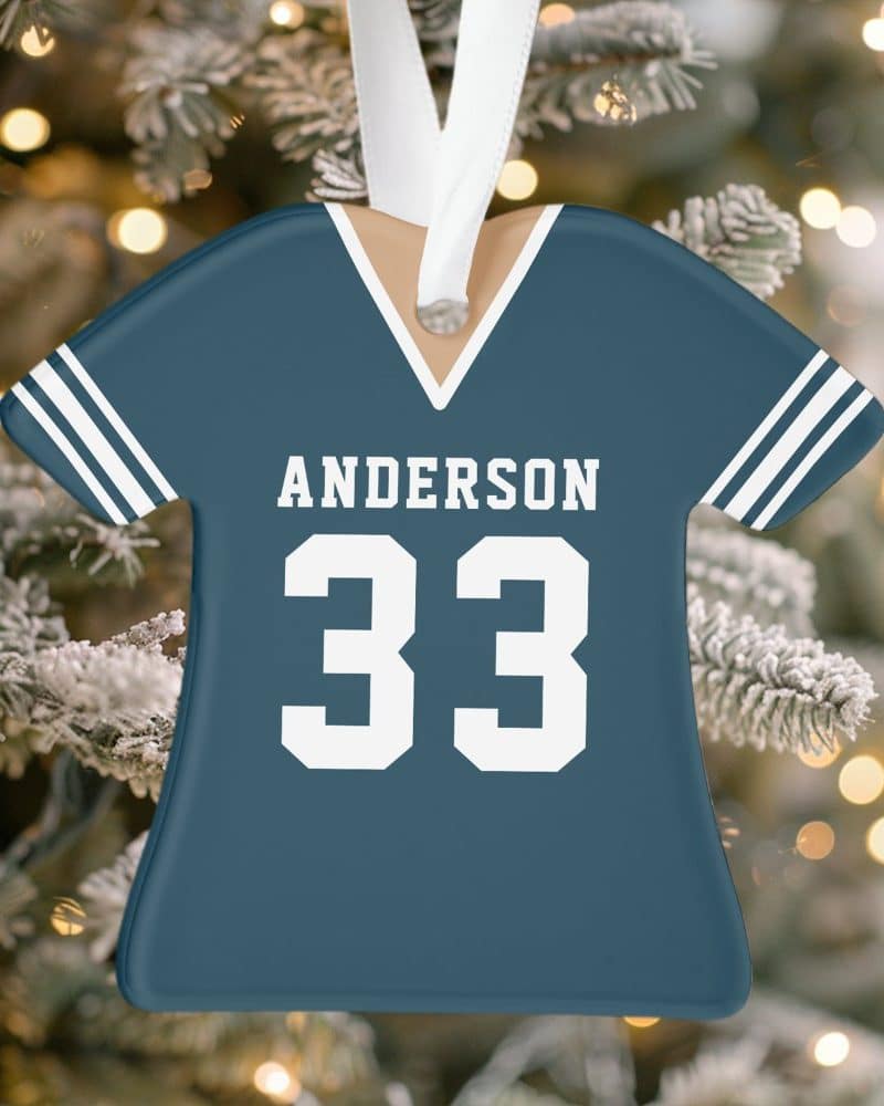 A teal blue jersey-shaped Christmas ornament with the name Anderson and number 33.