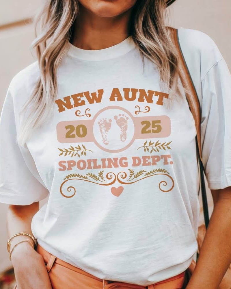 A white t-shirt with a design announcing New Aunt 2025 Spoiling Dept., featuring baby footprints.