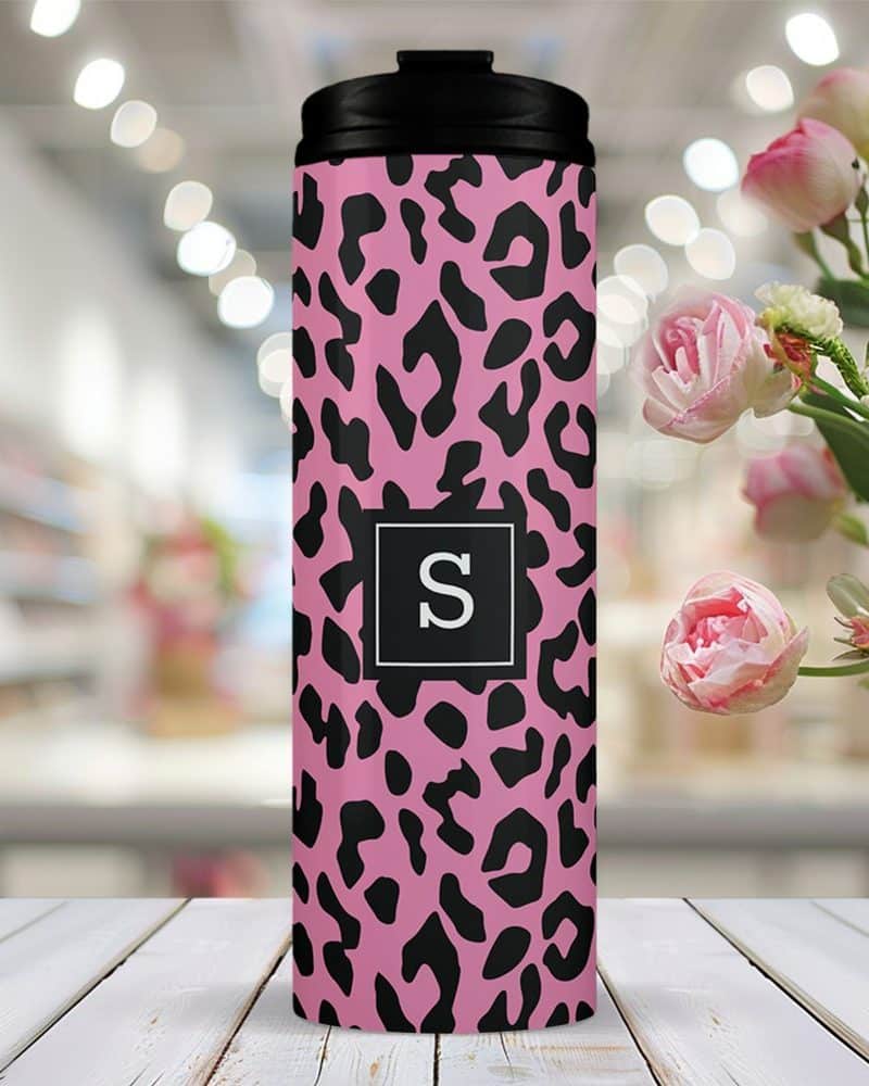 Pink travel tumbler with a black leopard print and a black square featuring the letter S in the center.