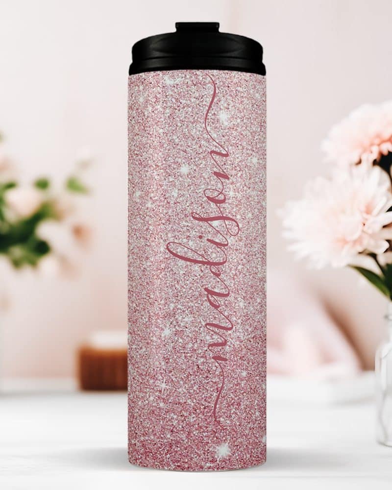 Pink glitter travel tumbler with the name Madison in a cursive script.