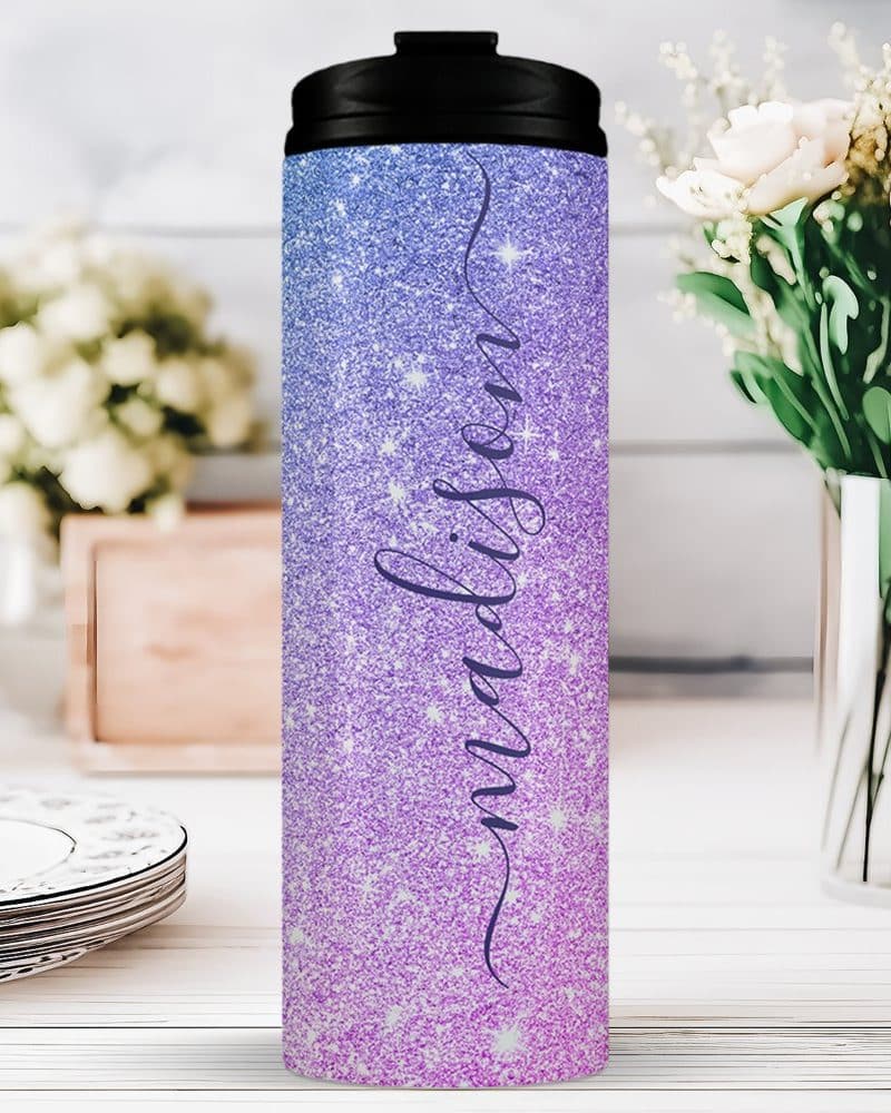 A purple and pink glitter tumbler with the name Madison on it.
