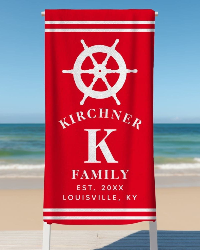 Red beach towel with a white ship's wheel, the letter K, and the Kirchener family name.