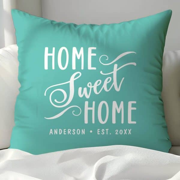 Teal Pillow With The Words Home Sweet Home In White Script Lettering. A Family Name And Establishment Year Are Also Visible At The Bottom.