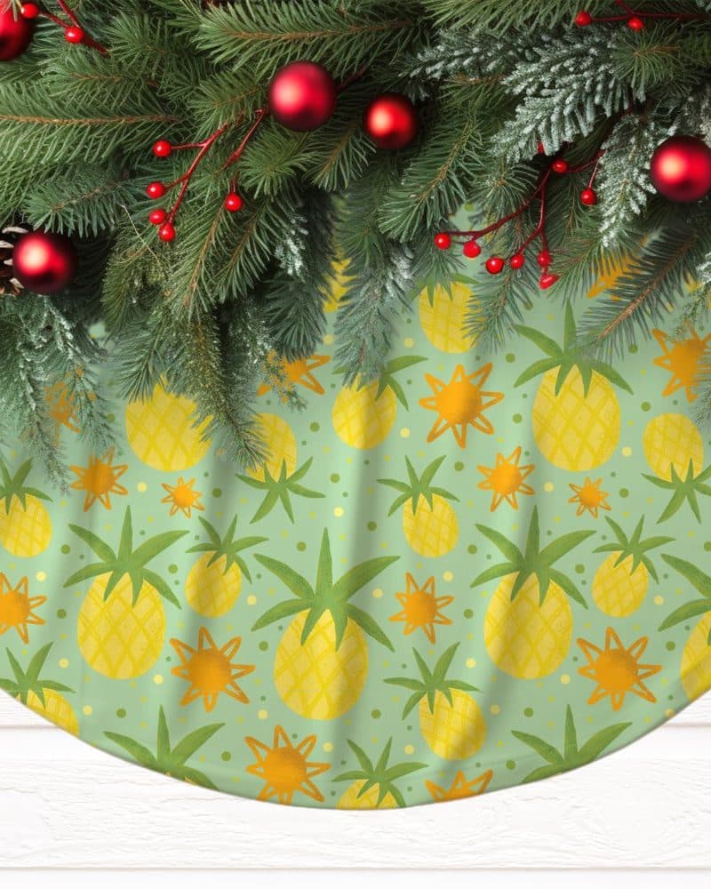 A Christmas tree skirt with a light green background and a repeating pattern of yellow pineapples and orange suns.