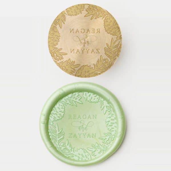Two Round Wax Seals, One Gold And One Light Green, Each Decorated With A Leafy Border And Personalized Text.