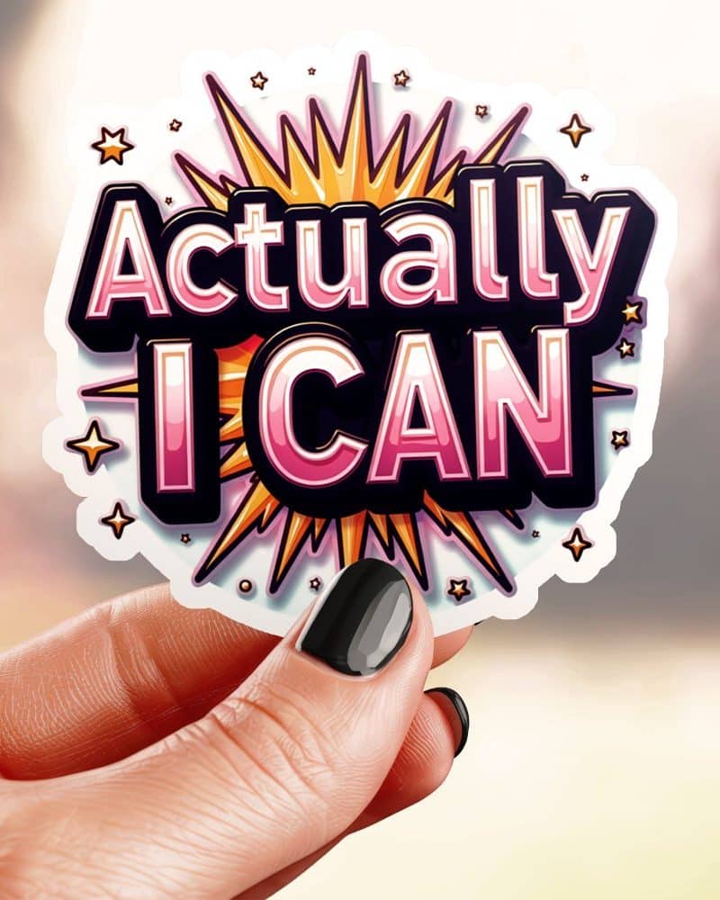 Hand holding a sticker that says Actually I Can in stylized lettering with a starburst design.