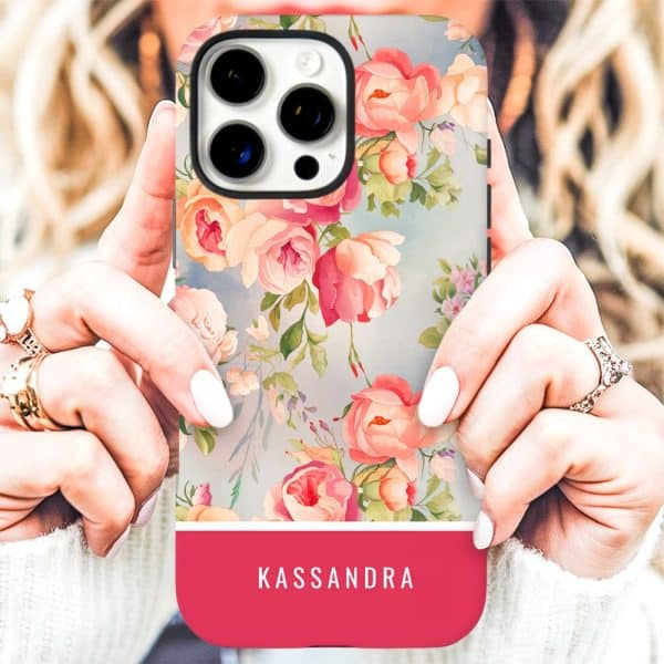 A Person'S Hands Holding A Phone Case With A Floral Design And The Name Kassandra On A Pink Band At The Bottom.