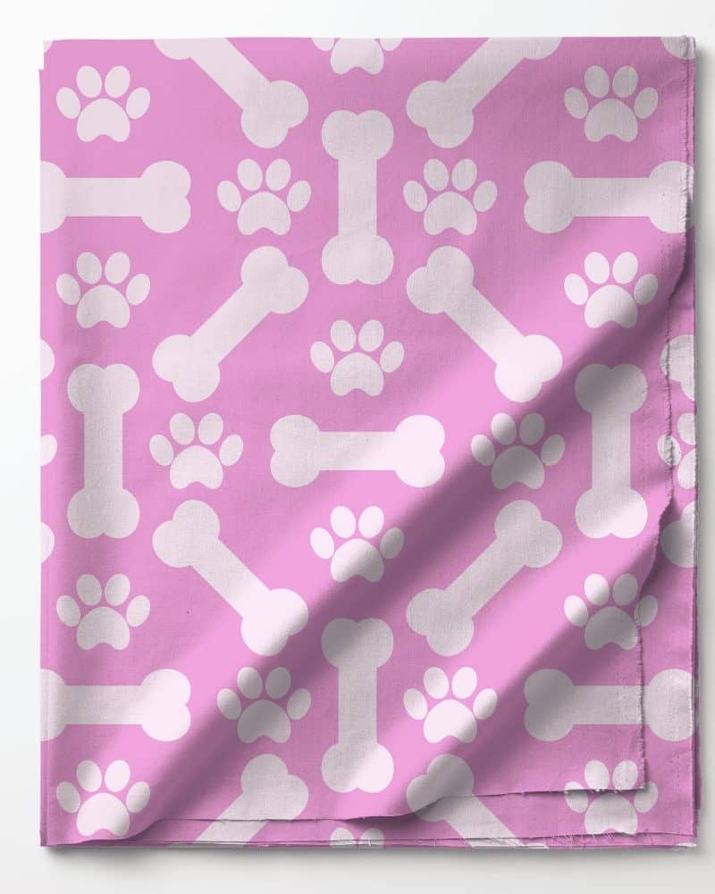 Pink fabric with a repeating pattern of white paw prints and bones.
