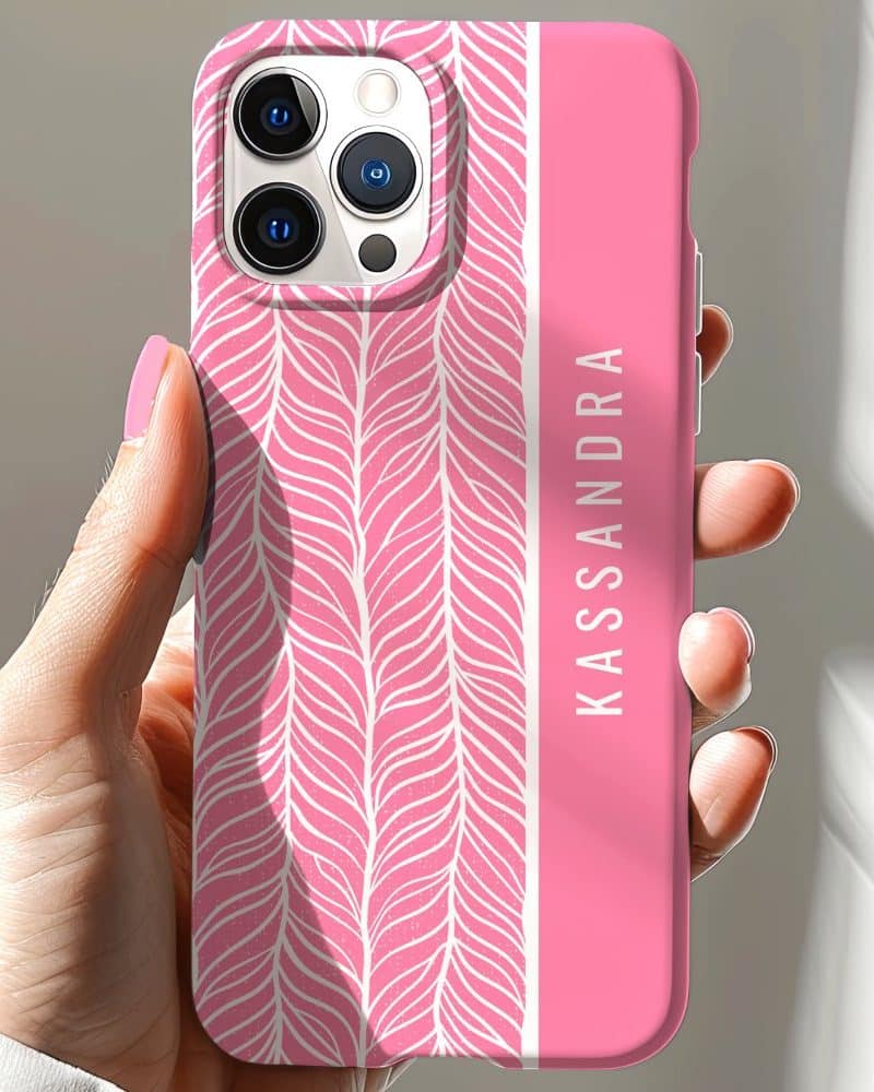 Pink phone case with a white leaf pattern and the name Kassandra on the side.