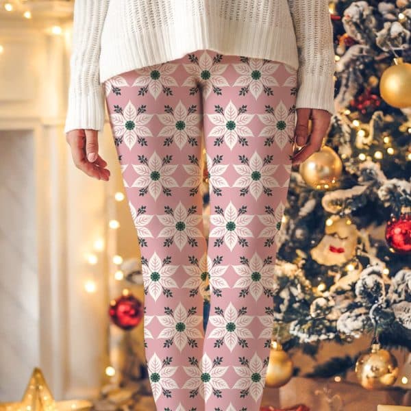 Pink Leggings With A Repeating Pattern Of Off-White Poinsettia Flowers And Dark Green Leaves.