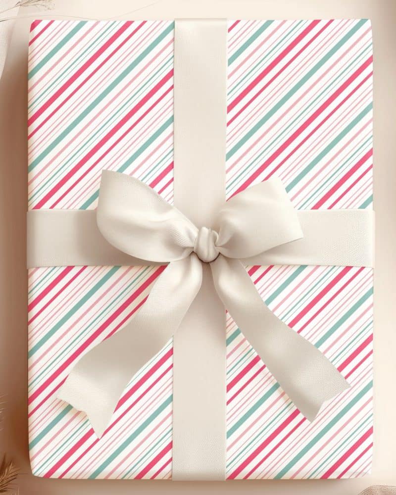 A gift wrapped in pink, red, and green diagonal striped paper with a large cream-colored bow.