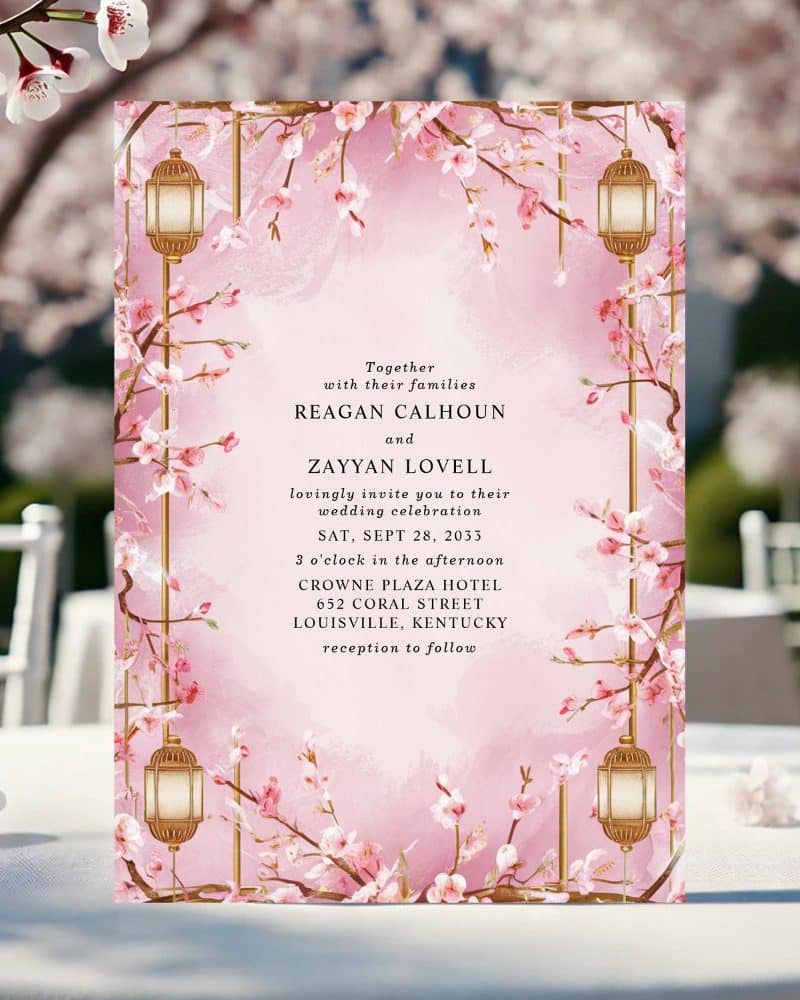 Wedding invitation with pink cherry blossoms and gold lanterns.