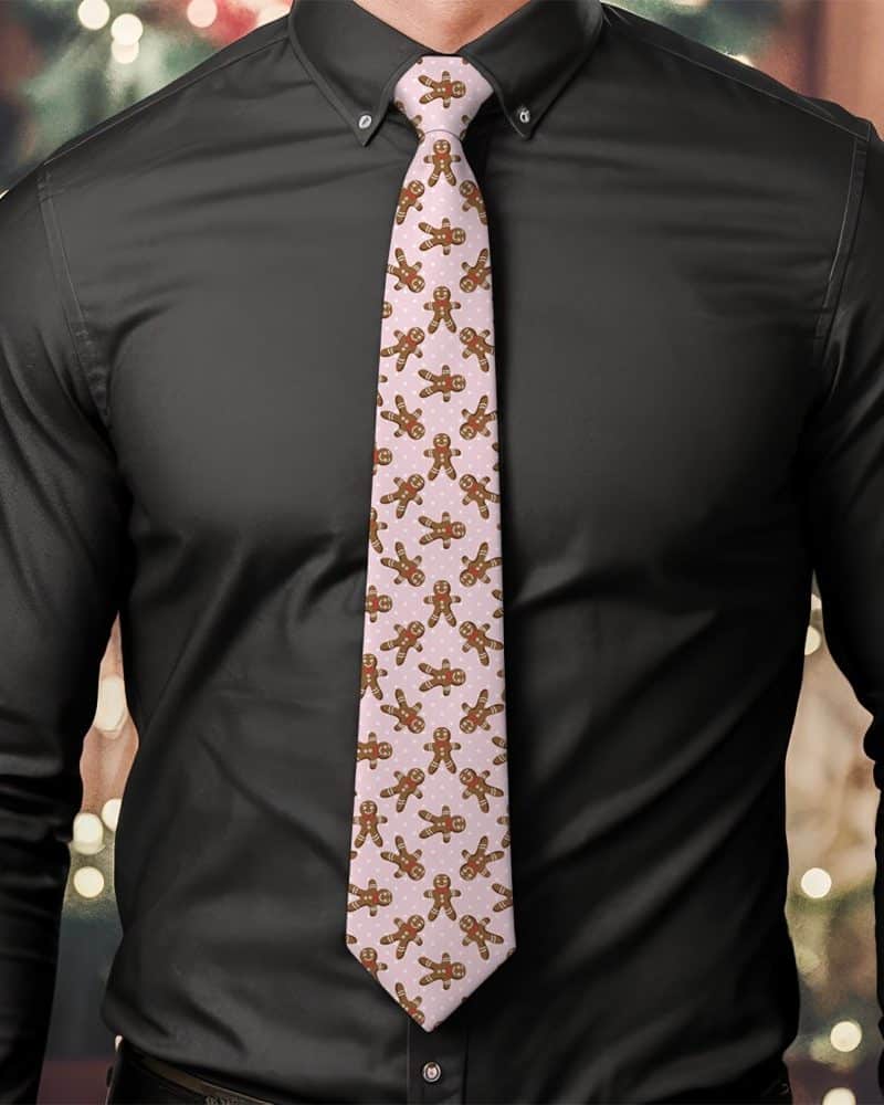 Man wearing a pink tie featuring a repeating pattern of gingerbread men.