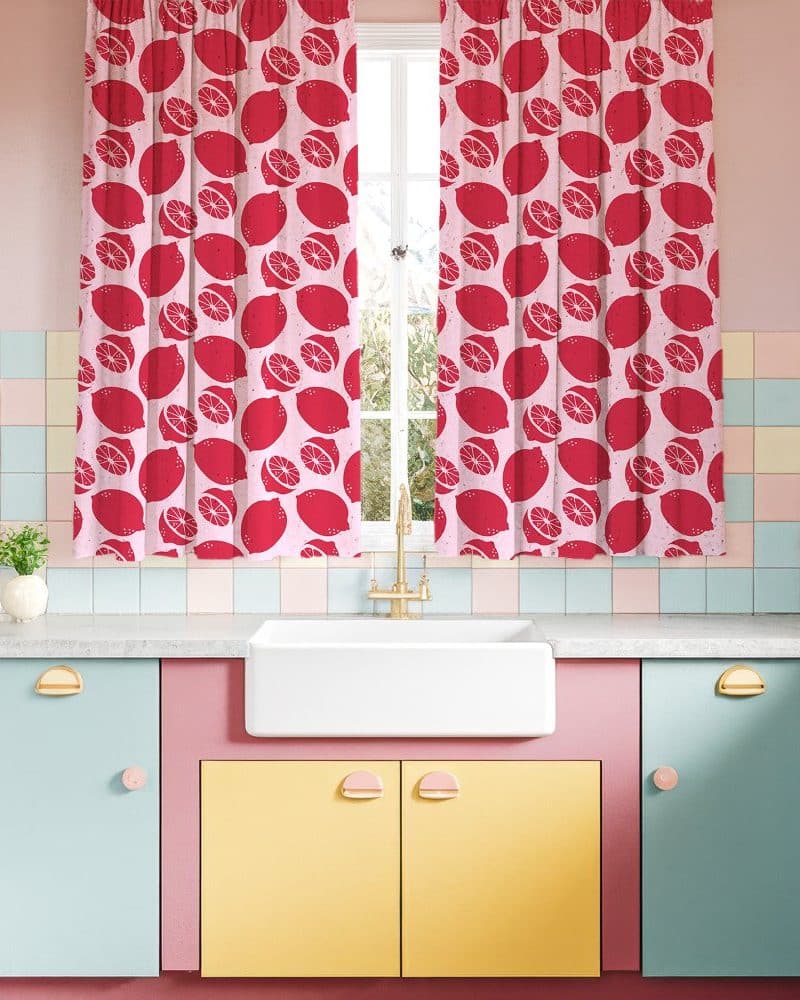 Pink kitchen window with red lemon patterned curtains.