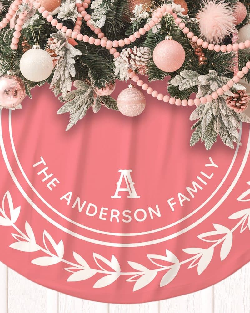 Pink Christmas tree skirt with a white circle design featuring the Anderson family name and initial A.