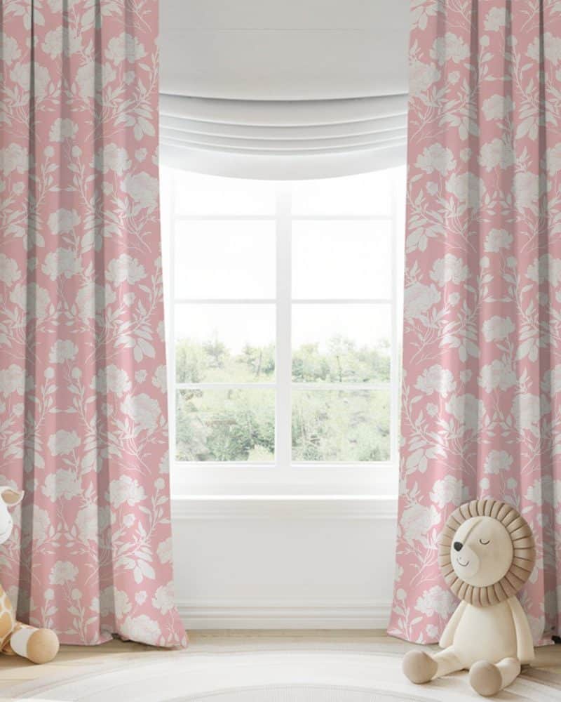 Pink curtains with a white floral pattern hang on a window.
