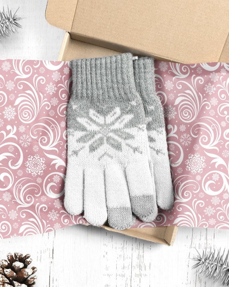 Pair of grey and white snowflake patterned knit gloves in a gift box.
