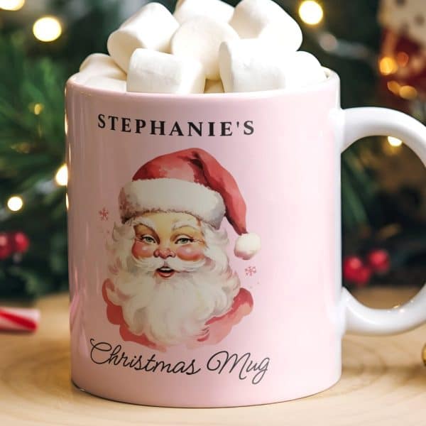 Pink Mug With Santa Claus Illustration, Personalized With The Name Stephanie'S And The Words Christmas Mug. The Mug Contains Marshmallows.