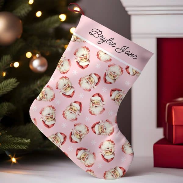Pink Christmas Stocking With A Repeating Pattern Of Santa Claus Faces, Personalized With The Name Brylee Jane.