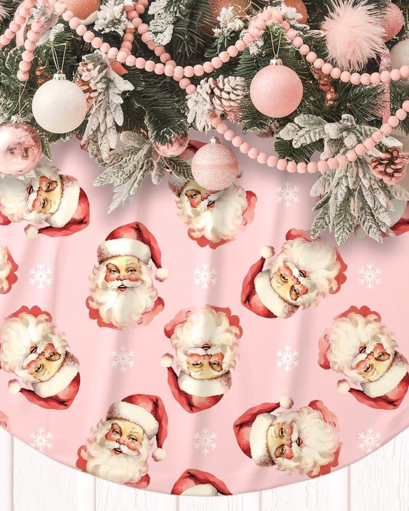 Pink Christmas tree skirt with a repeating pattern of Santa Claus faces.