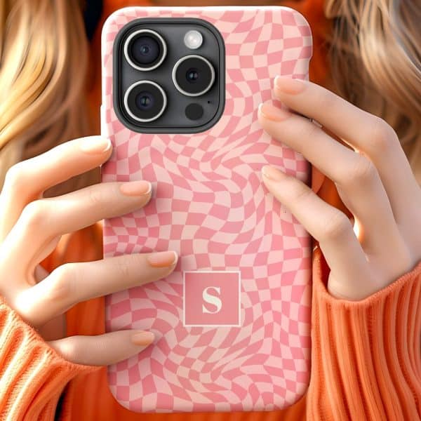 Close Up Of Hands Holding A Pink Phone Case With A Wavy Checkered Pattern And A Letter S In The Center.