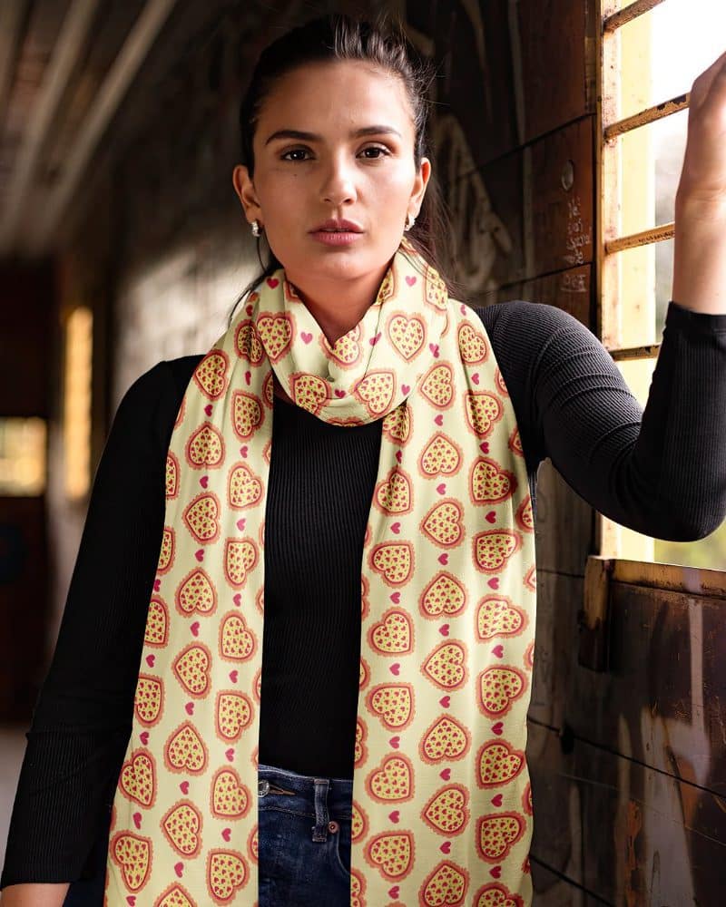 Woman wearing a long yellow scarf with a pizza slice heart pattern.