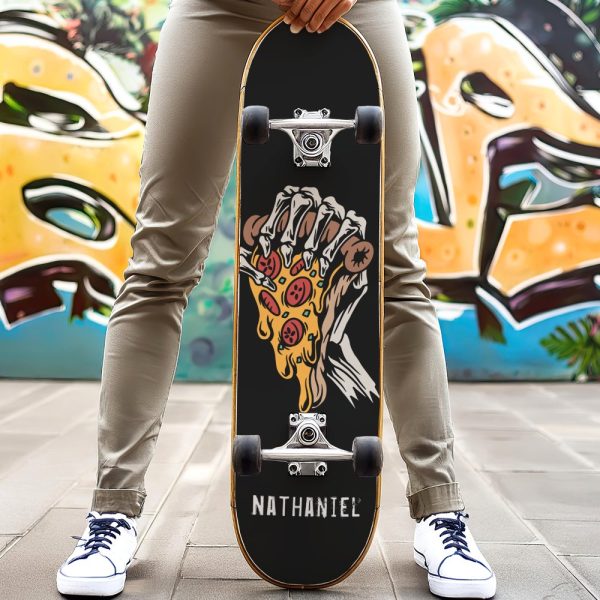Person Holding A Black Skateboard With A Graphic Of A Skeleton Hand Holding A Dripping Pizza Slice. The Name Nathaniel Is Printed On The Board.