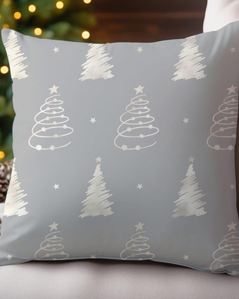 Gray throw pillow with a repeating pattern of silver Christmas trees and stars.