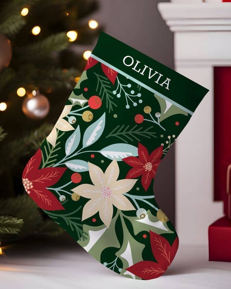 Personalized Christmas stocking with a dark green background, featuring a repeating pattern of red and cream poinsettias and green foliage. The name Olivia is printed at the top.