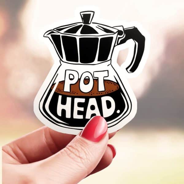 Hand Holding A Sticker Of A Coffee Pot With The Words Pot Head.