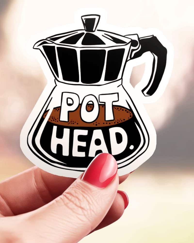 Hand holding a sticker of a coffee pot with the words Pot Head.