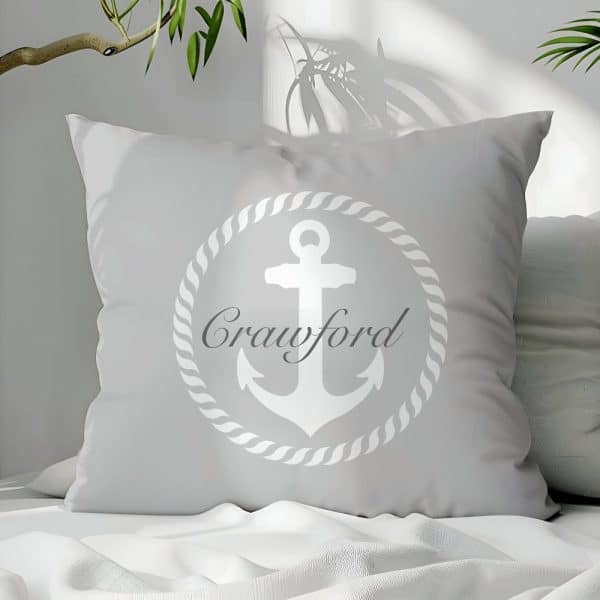 Light Gray Square Pillow With A White Anchor Design Inside A Rope Circle And The Name Crawford.