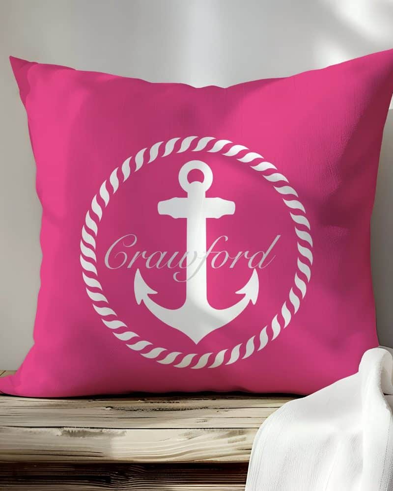 Pink pillow with a white anchor and the name Crawford in a rope circle design.