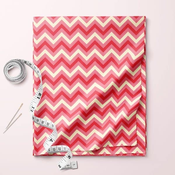 Pink And Cream Chevron Patterned Fabric With A Measuring Tape And Pins.
