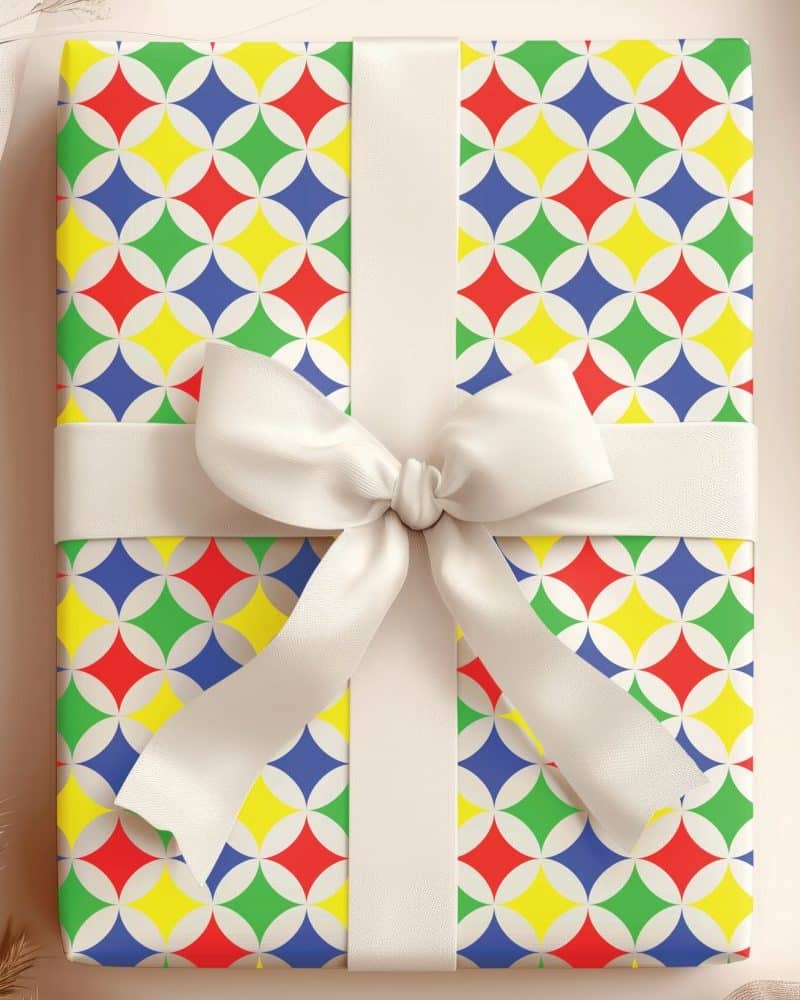 Gift box with colorful geometric pattern and white ribbon.