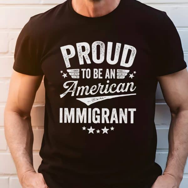 Person Wearing A Black T-Shirt That Says Proud To Be An American Immigrant.