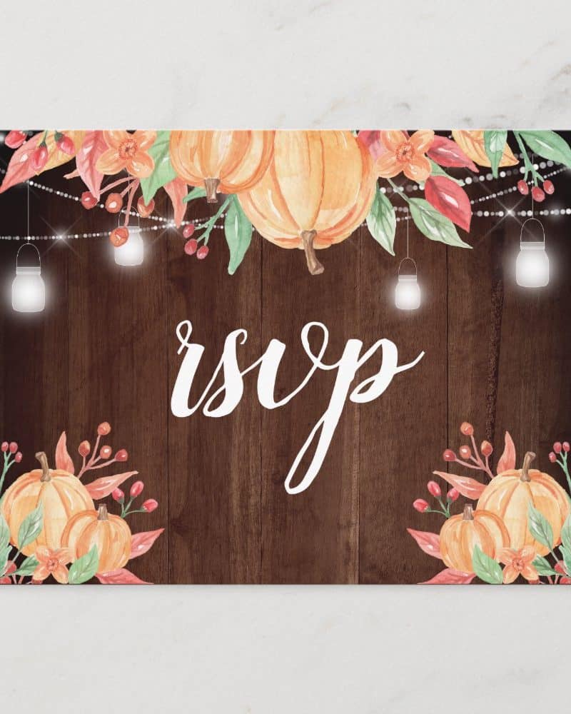 Fall-themed RSVP card with pumpkins, flowers, and string lights on a wood background.