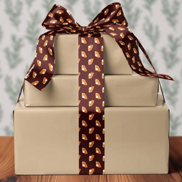 Three Stacked Presents Tied With A Brown Ribbon Featuring A Pattern Of Pumpkin Pie Slices.
